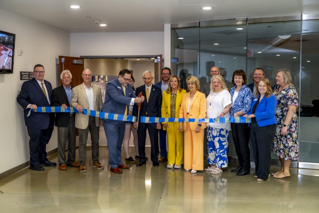 Rose State College President Travis Hurst cuts the ceremonial ribbon alongside college leaders, community partners, and supporters during the dedication of the expanded Health Sciences Center.