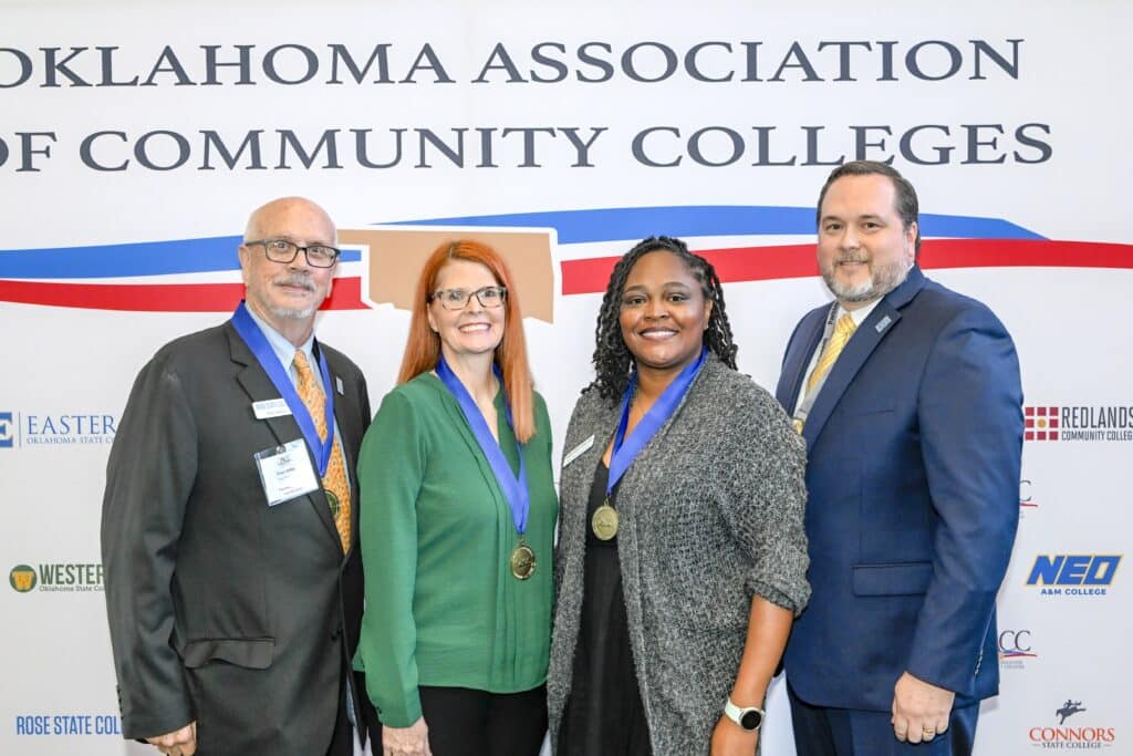 RSC staff smile with President Hurst in front of an OACC backdrop.