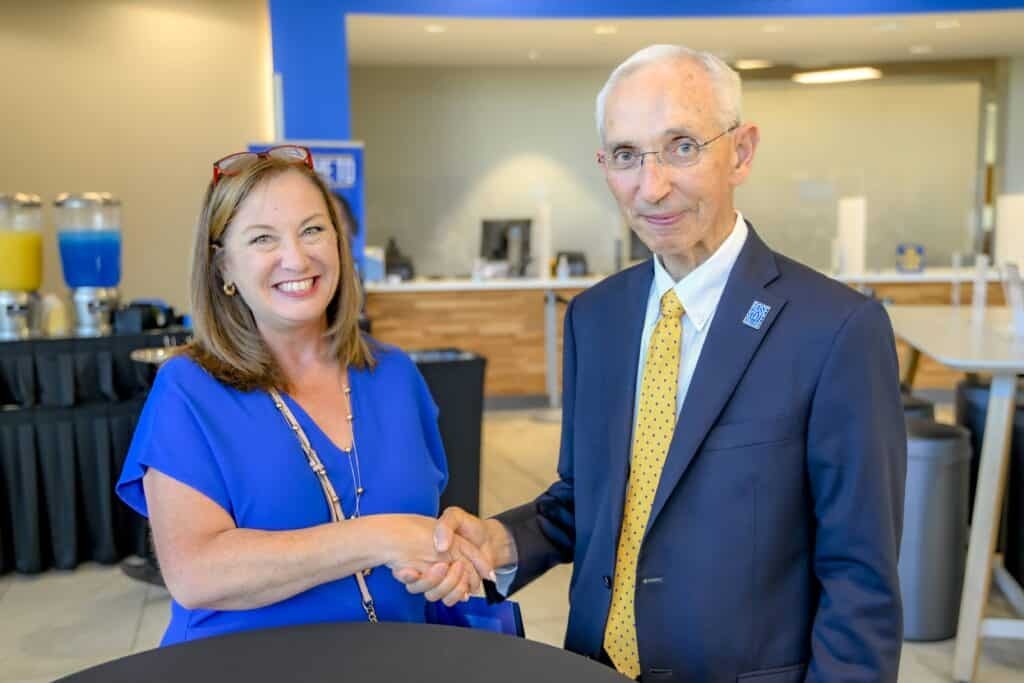 Anita Poole-Endsley and Norm Mejstrik shake hands during a Rose State College event.