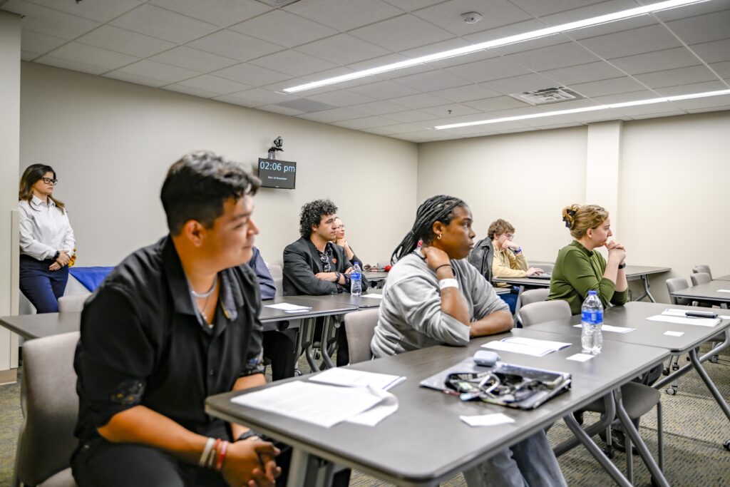 Rose State College students sit at classroom tables during a Phi Theta Kappa Honor Society event, listening to a presentation.