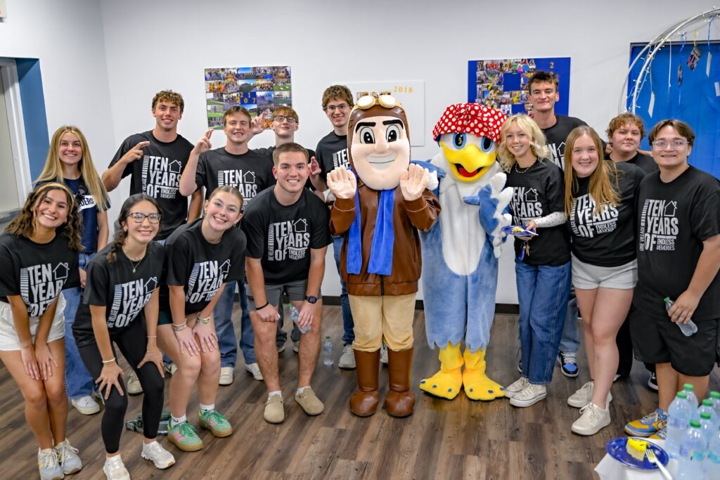 Rose State College students pose for a group photo at The Village 10-year anniversary celebration with the Raider mascot and a bird mascot.