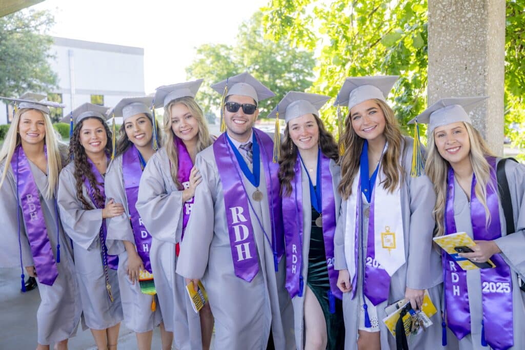 one male and several female RSC students pose for a picture at commencement